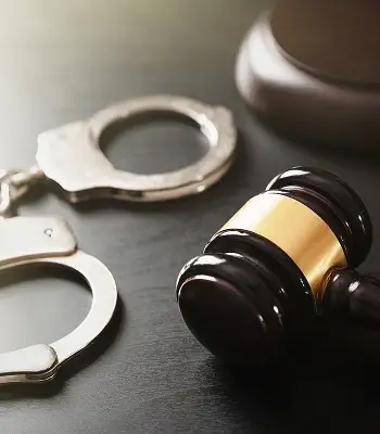 a gavel and handcuffs on a table