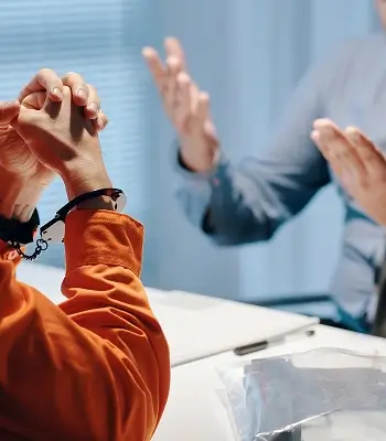 the suspect is in handcuffs and talking to his lawyer.