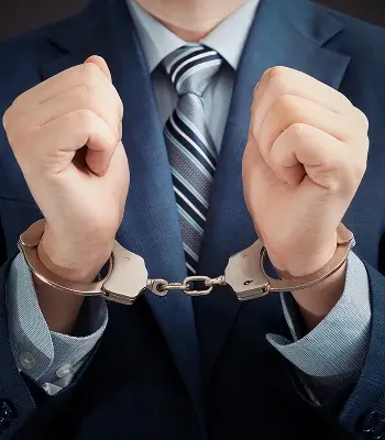 a man in a suit and tie with handcuffs