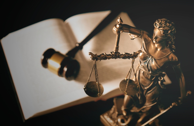 Lady Justice statue in law and books in background