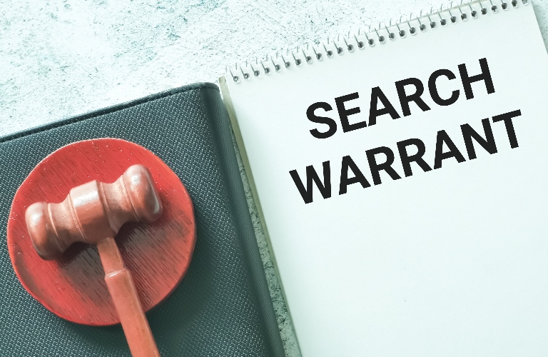 search warrant written on note book with gavel