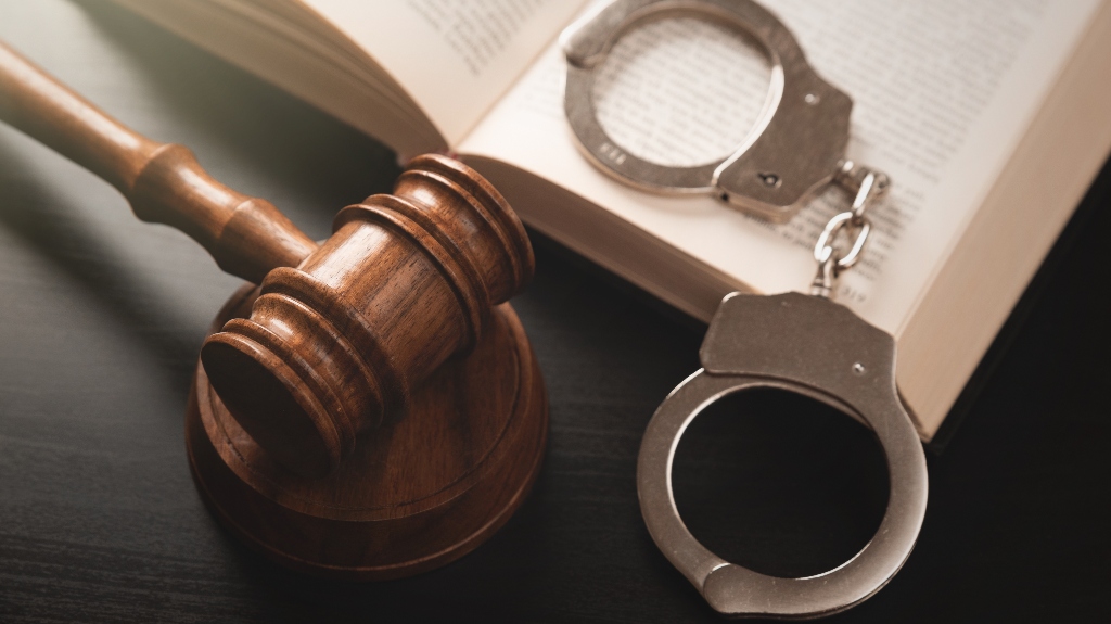 Metal handcuffs near judge's gavel