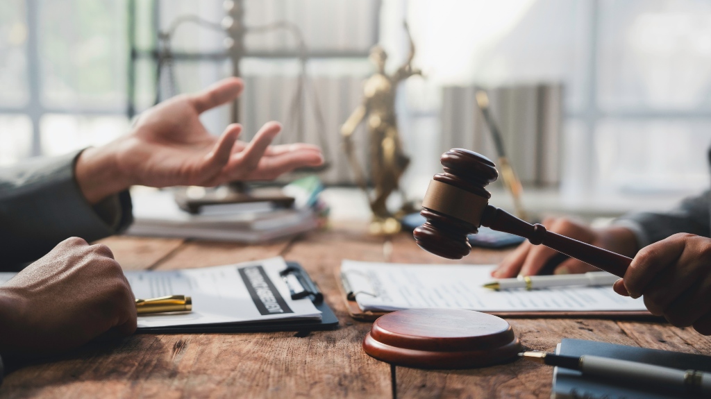 Judge holding a gavel while presiding over a legal discussion with a person